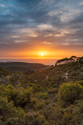 Sunset over the lush green hills typical of the southern Brazilian landscape