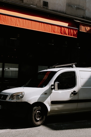 a white car parked in front of a building
