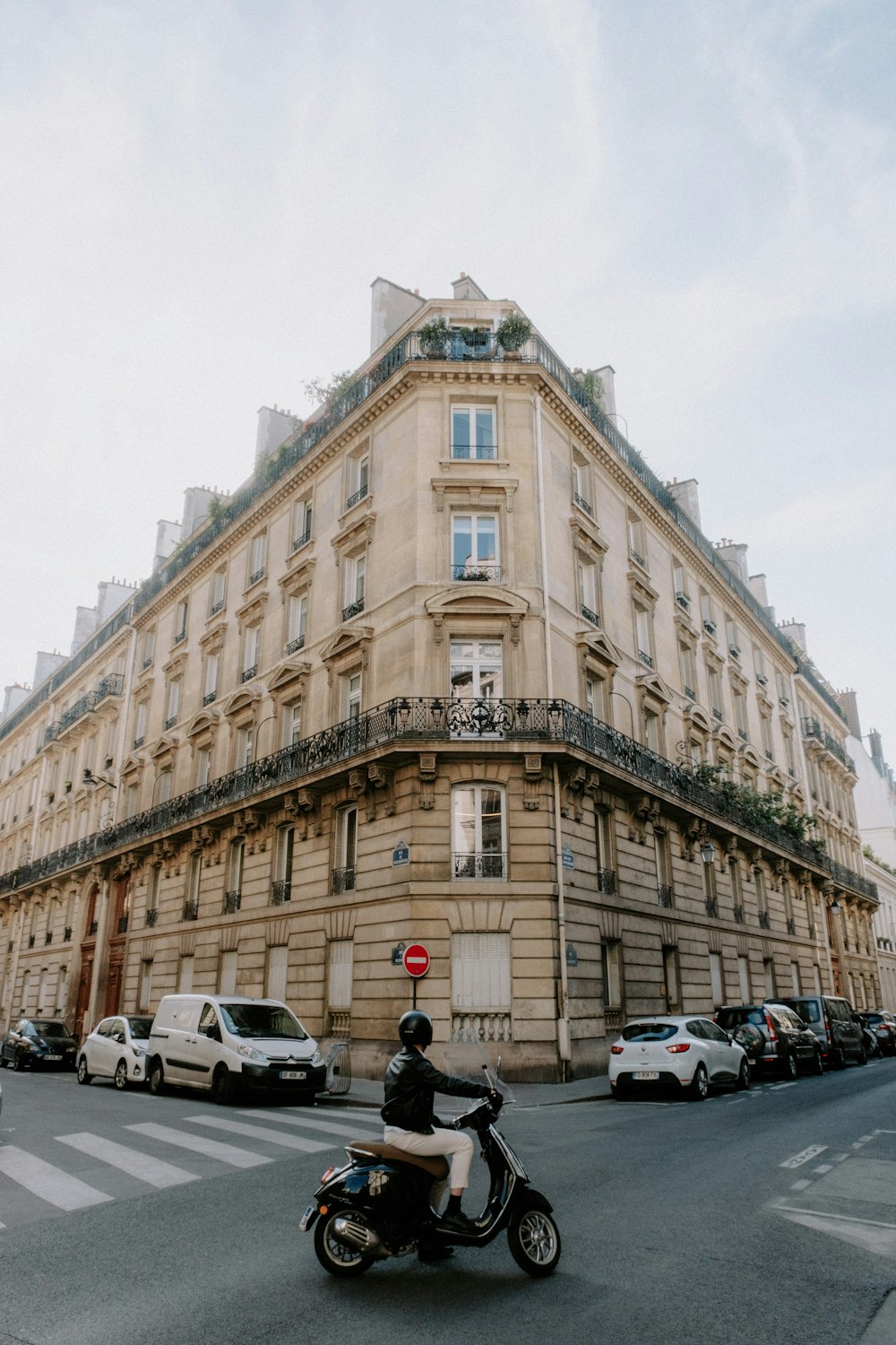 a person riding a motorcycle in front of a large building