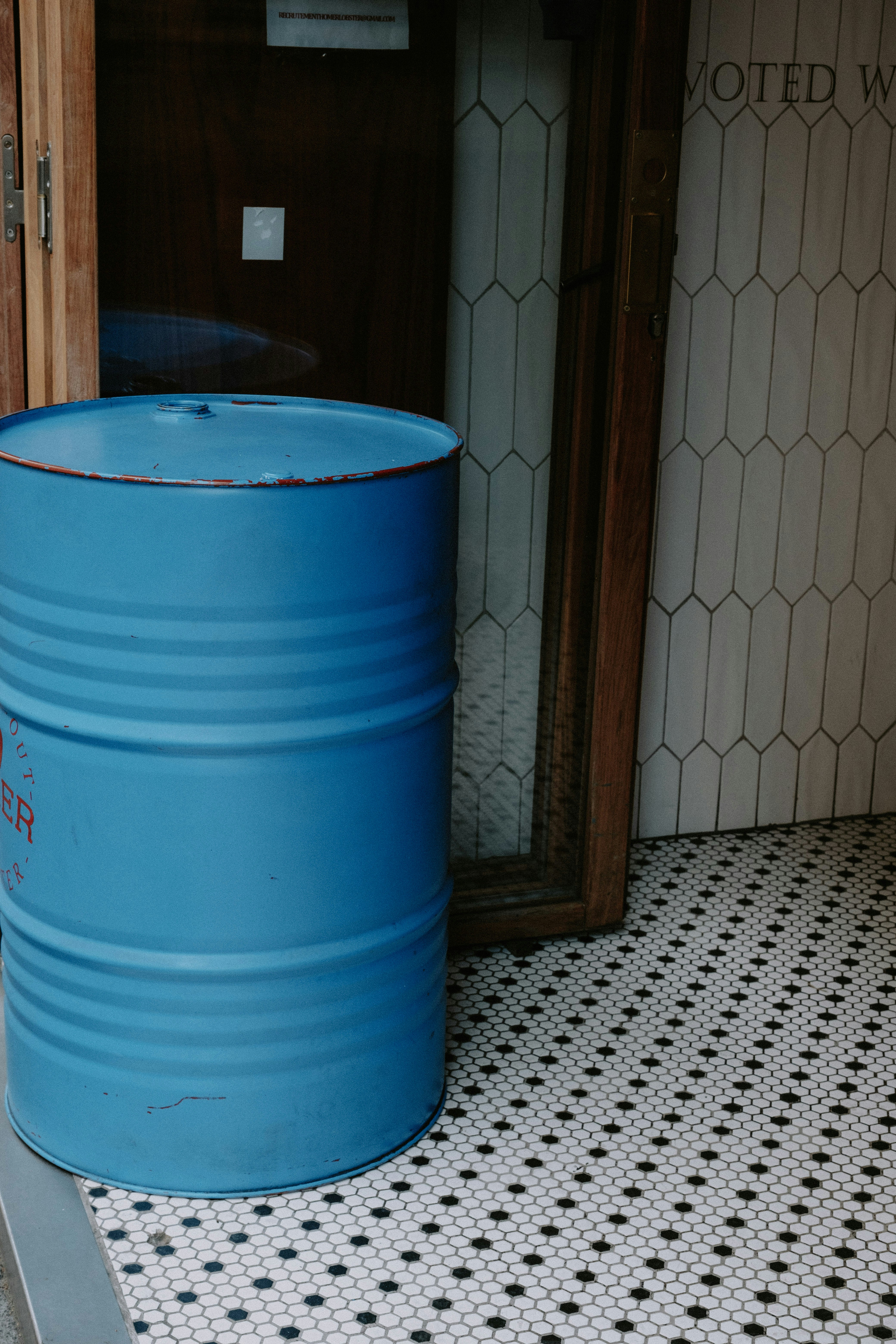 a blue bucket on a tile floor