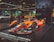 A sleek, orange and black Formula E race car displayed prominently on a raised platform at an auto show. The car is branded with Nissan and various other sponsor logos. Surrounding the car are other vehicles and a few people examining the exhibits. Large banners with advertising slogans hang in the background, along with an urban skyline image.