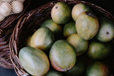 A vibrant basket overflowing with freshly picked ripe mangoes.
