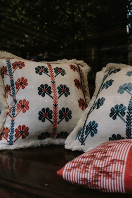Embroidered throw pillows featuring delicate floral patterns on a cozy window seat.