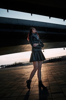 A model wearing a sleek, breathable jacket walking through a bustling urban street at sunset.