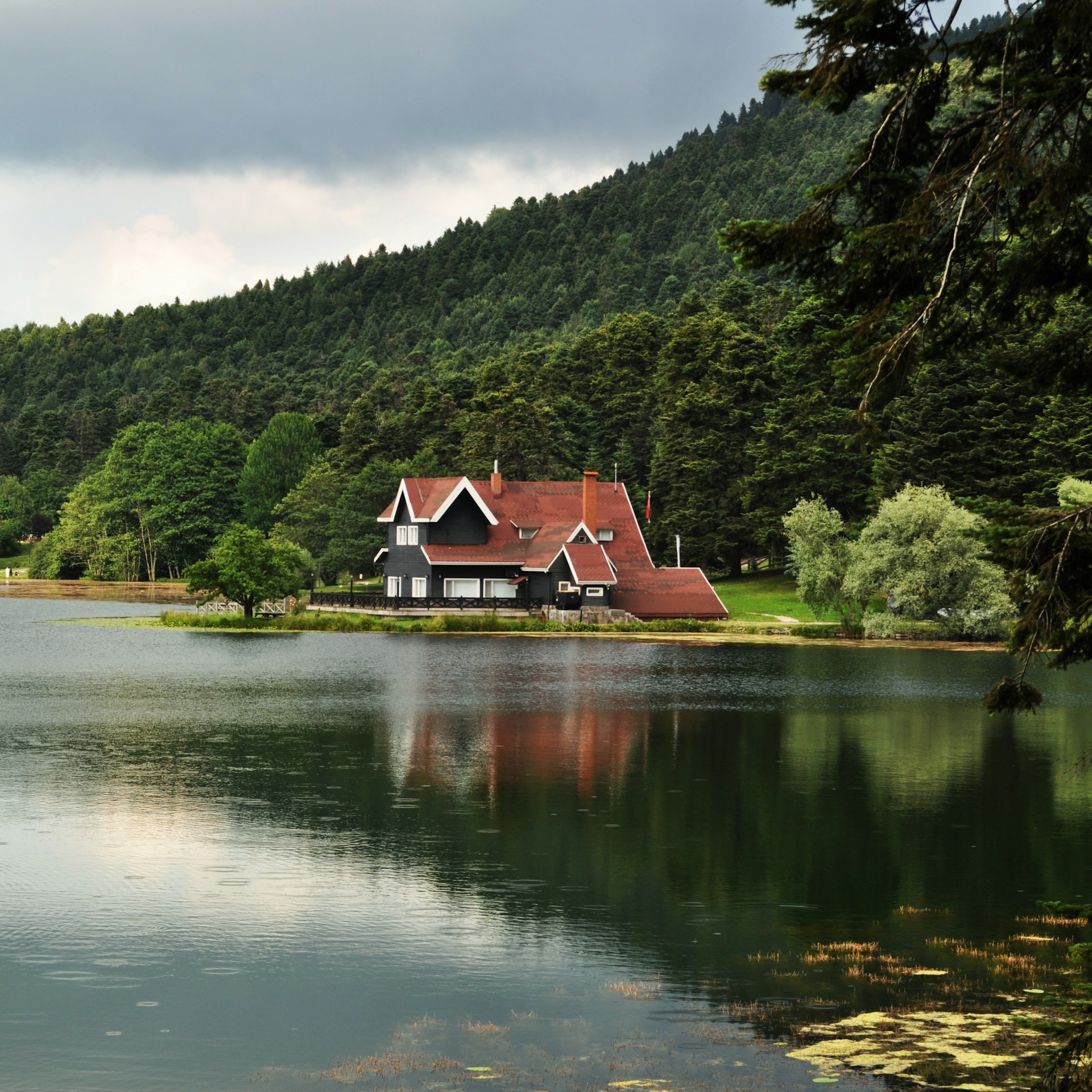 a house on a hill by a lake
