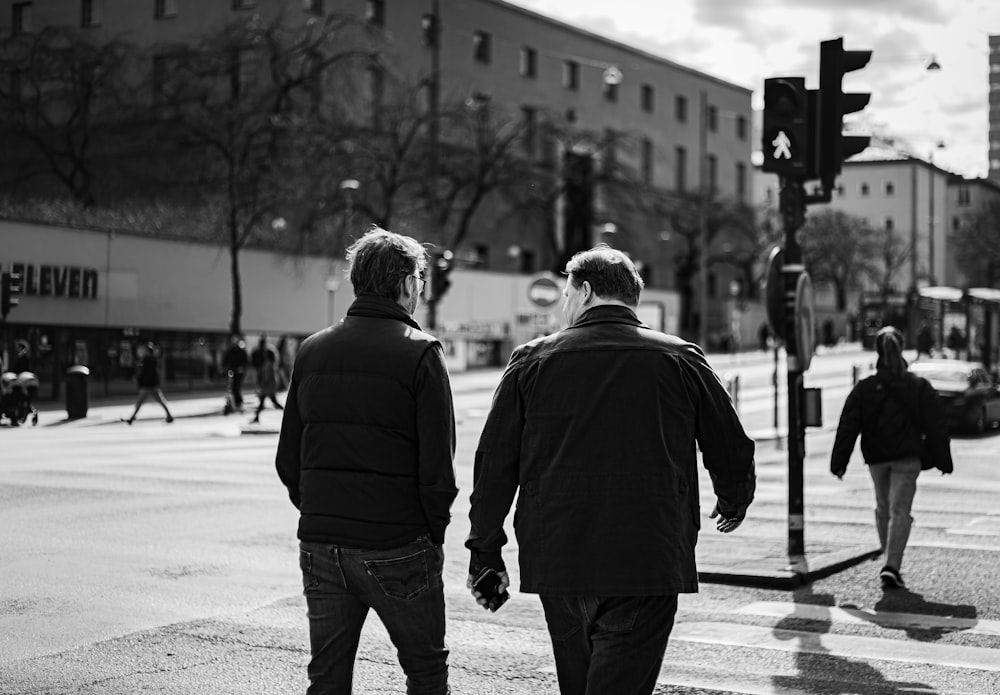 a couple of people walk across a crosswalk