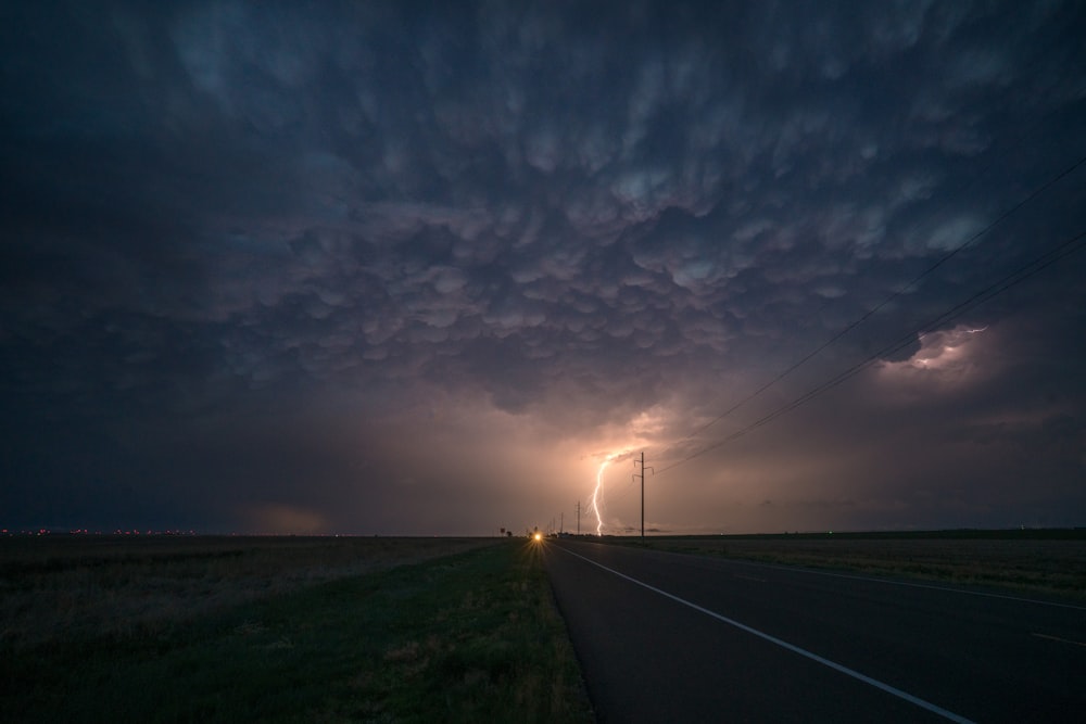 a road with a lightning bolt in the distance