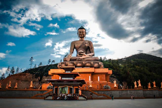 A large bronze Buddha statue sitting on a pedestal in Thimphu, Bhutan