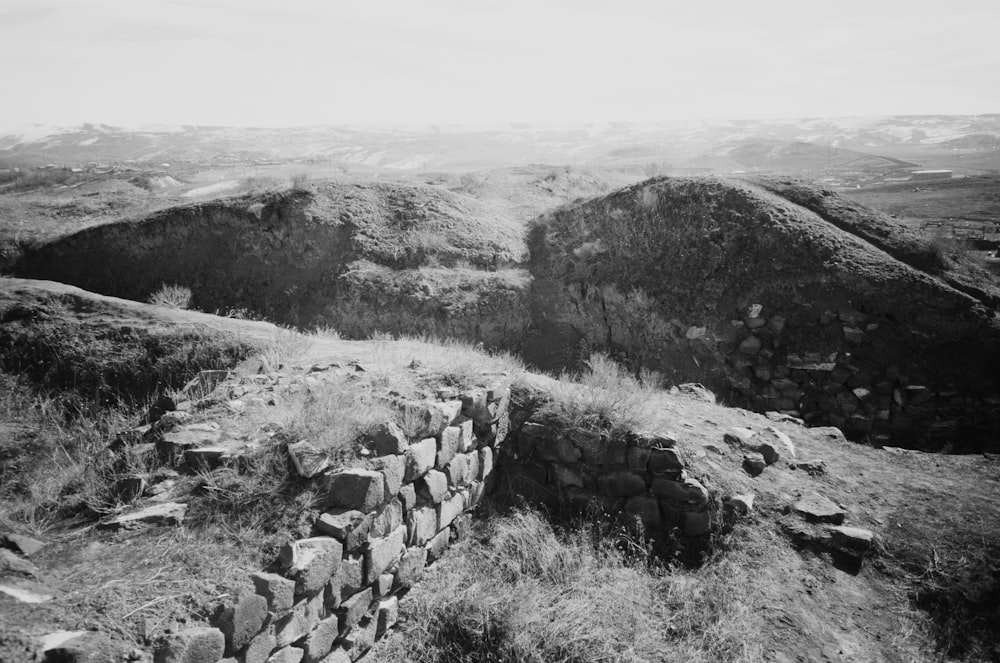 a rocky hillside with a stone wall