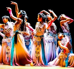 A group of dancers performing an energetic routine in colorful costumes.