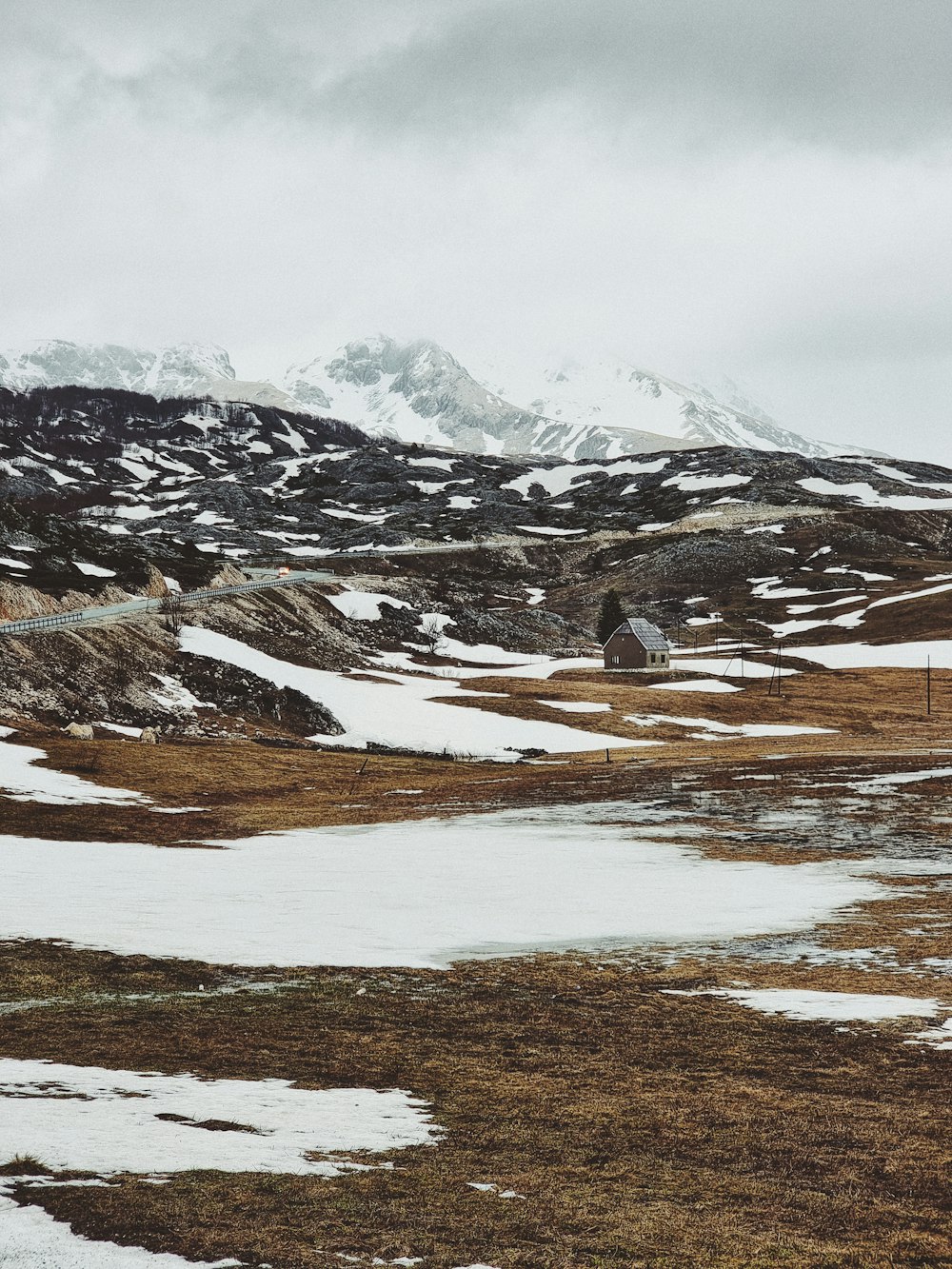 uma pequena casa em uma paisagem nevada