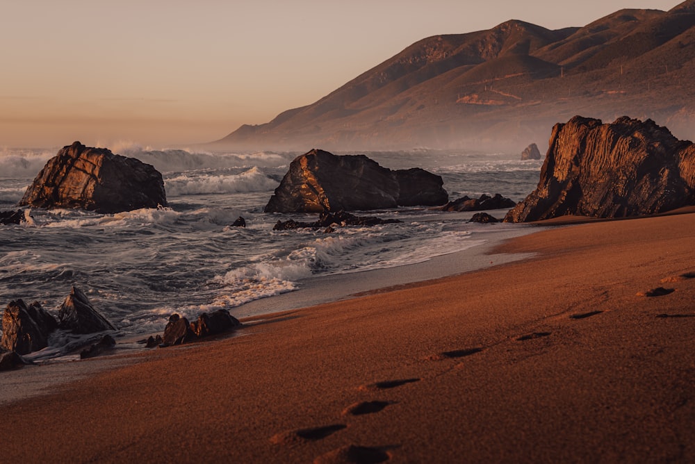 Ein Strand mit Felsen und Wasser