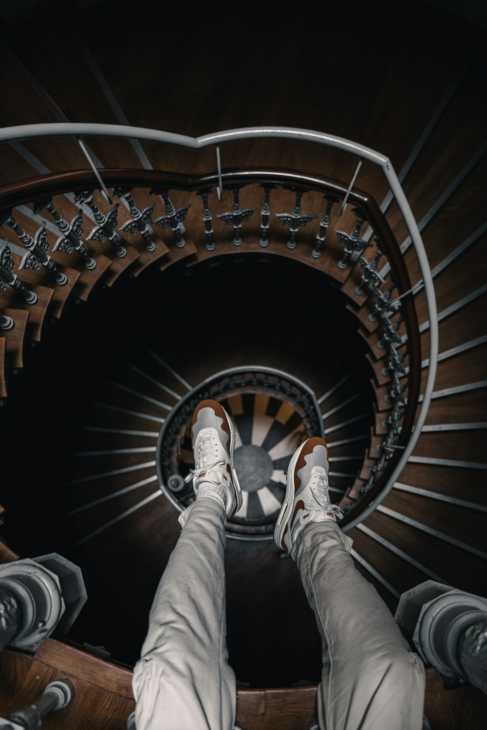 a person's feet on a metal spiral staircase