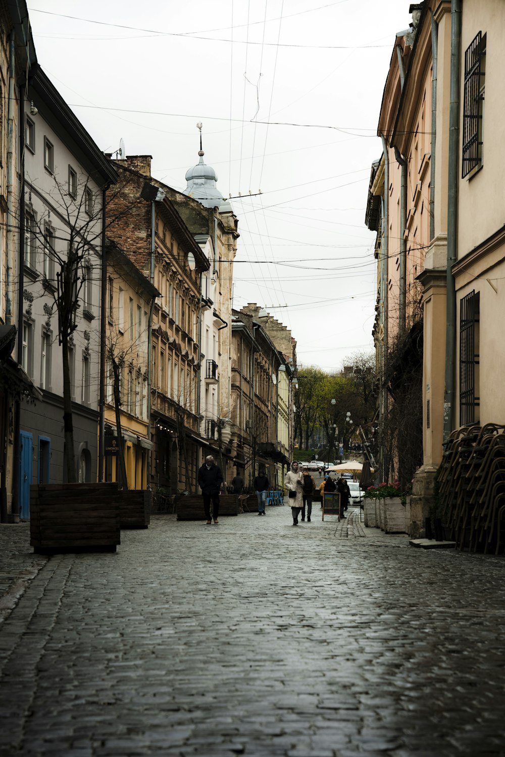 a cobblestone street with people walking on it