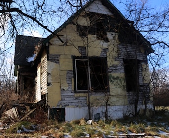 a run down house with trees around it
