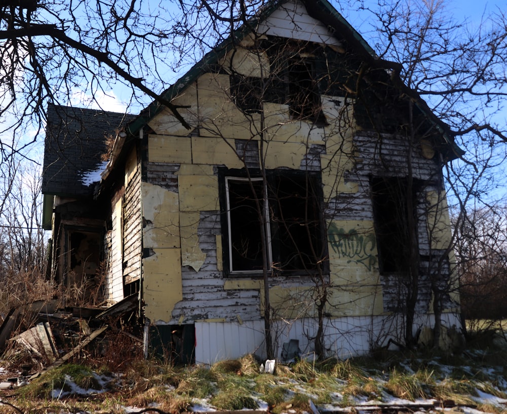 a run down house with trees around it