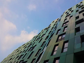 Modern sustainable building with green roofs and solar panels reflecting eco-friendly design.