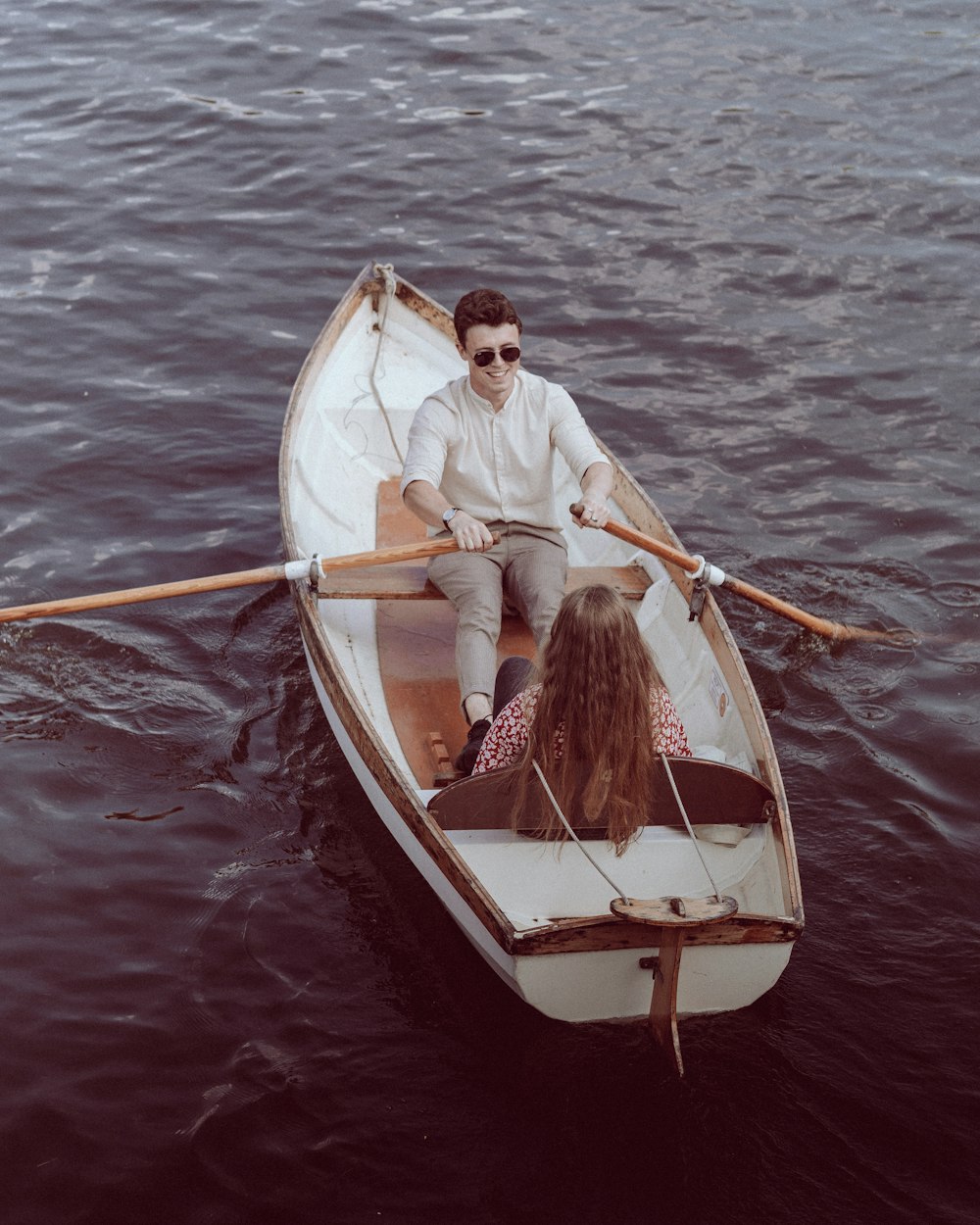 a man and a woman in a boat on water