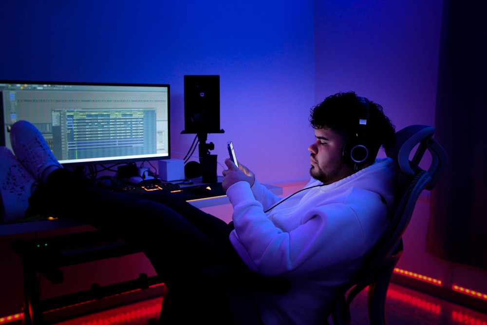 a man sitting at a desk with a laptop and headphones on