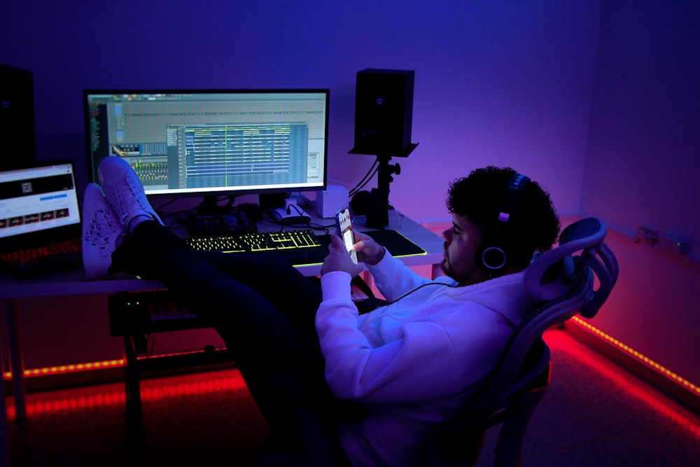 a man sitting at a desk with a laptop and a microphone