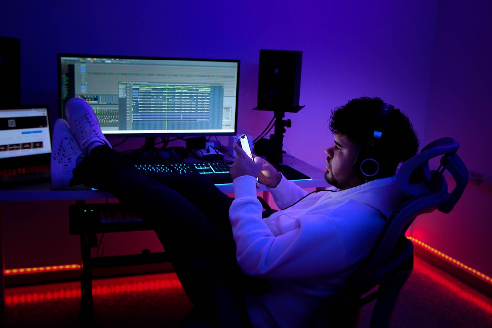 a man sitting at a desk with a laptop and a microphone