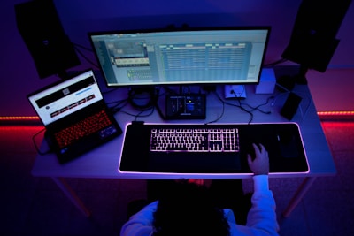 a person sitting at a desk with a computer and a keyboard