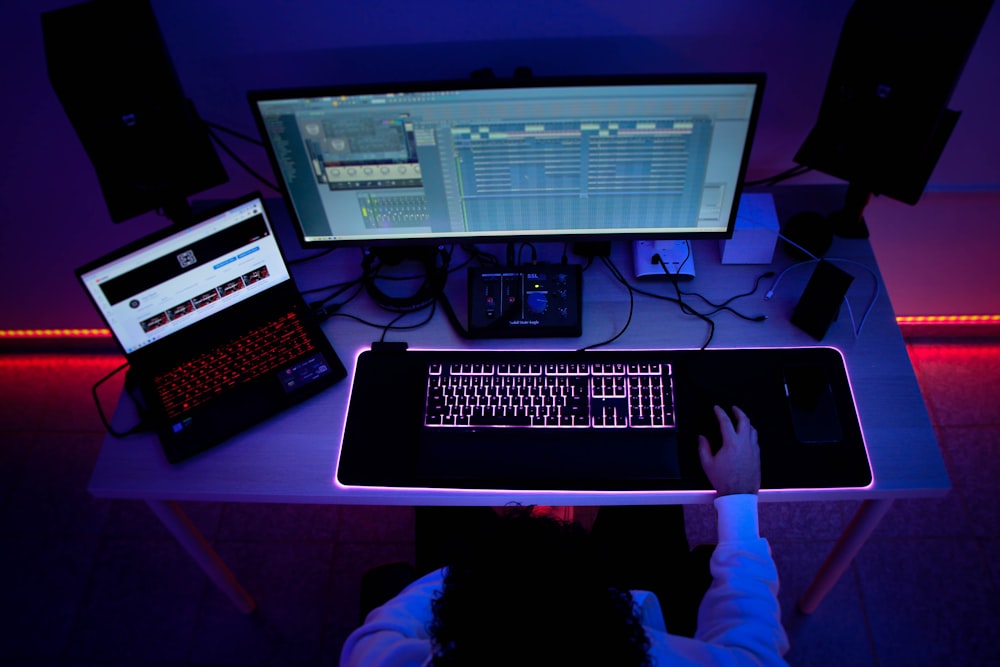 una persona seduta a una scrivania con un computer e una tastiera