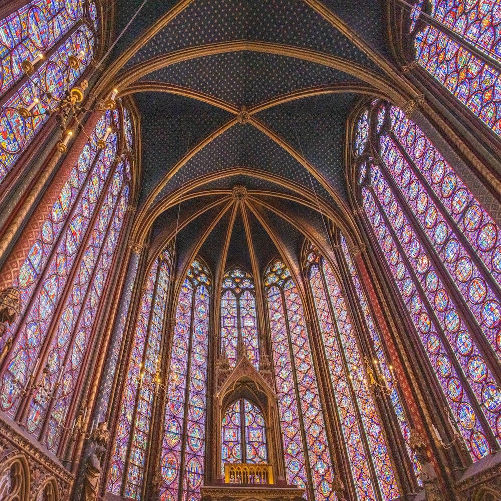 a large ornate ceiling with stained glass windows with Sainte-Chapelle in the background