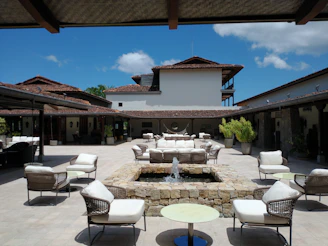A quaint stone courtyard adorned with vibrant bougainvillea and comfortable seating for relaxing afternoons.