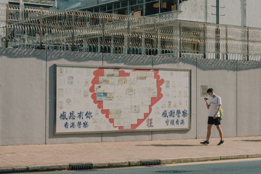 a person standing next to a large sign