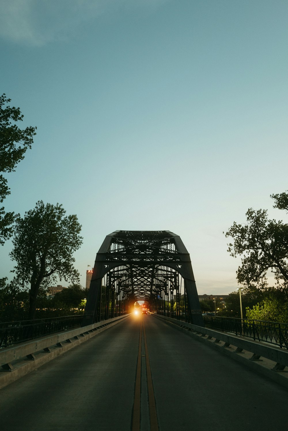 a car driving down a road under a bridge