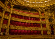 Inside Teatro alla Scala, showcasing its elegant red velvet seats and golden balconies.