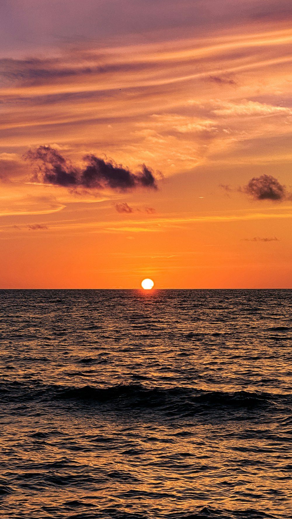 a sunset over the ocean with Sunset Beach in the background