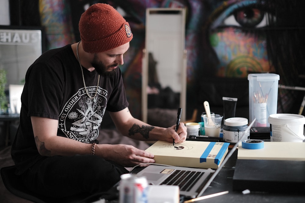 a person with a red hat writing on a laptop