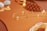 A close-up of elegant jewelry pieces, including a delicate gold chain with small pearls and a pair of ornate cufflinks set on a reflective gold surface. The background features intricate patterns that enhance the luxurious feel.