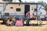 a group of people sitting outside a camper