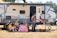 a group of people sitting outside a camper