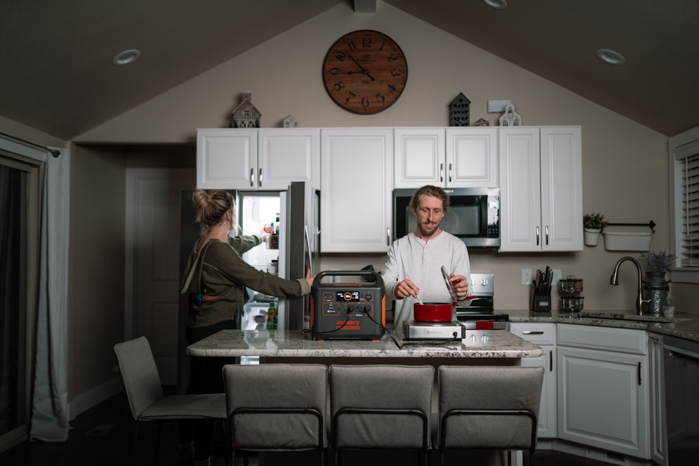 a couple of people stand in a kitchen