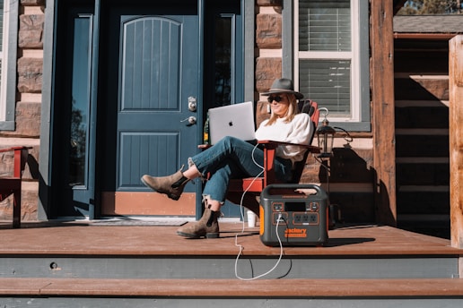 a person sitting on a chair with a laptop and a box