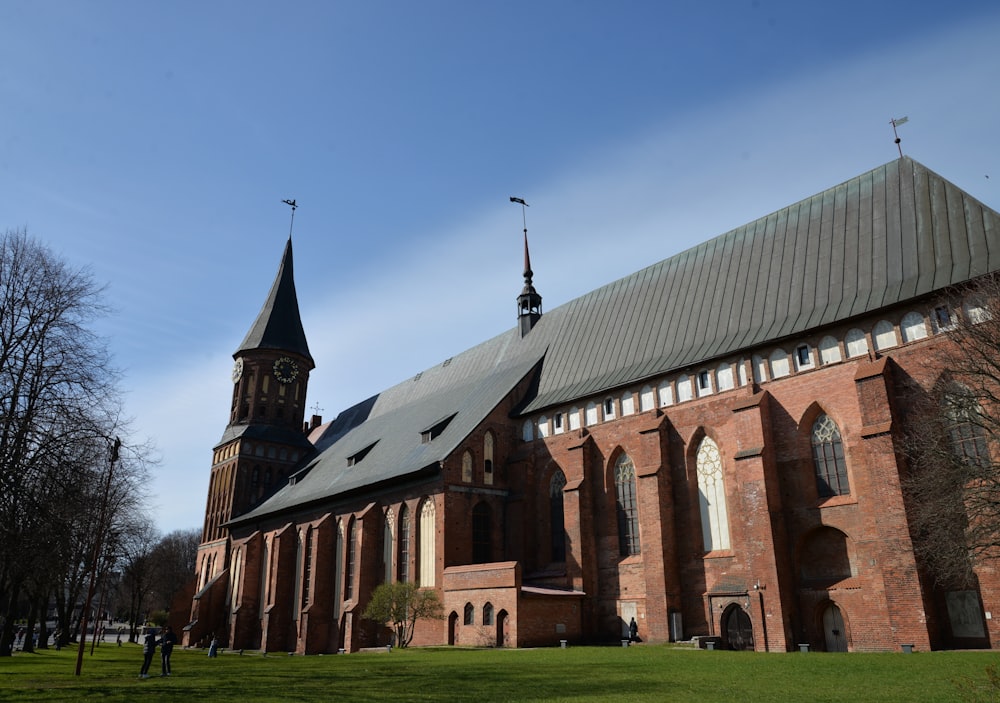 a large brick building with a green lawn in front of it