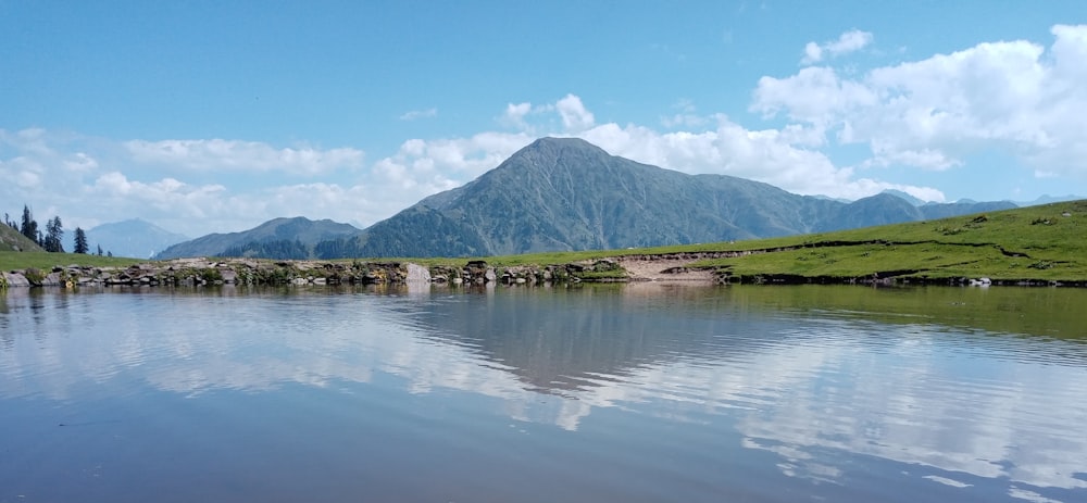 a body of water with a mountain in the background