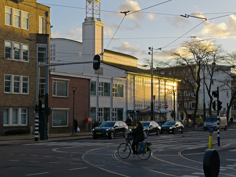 a person riding a bicycle on a street with cars and buildings