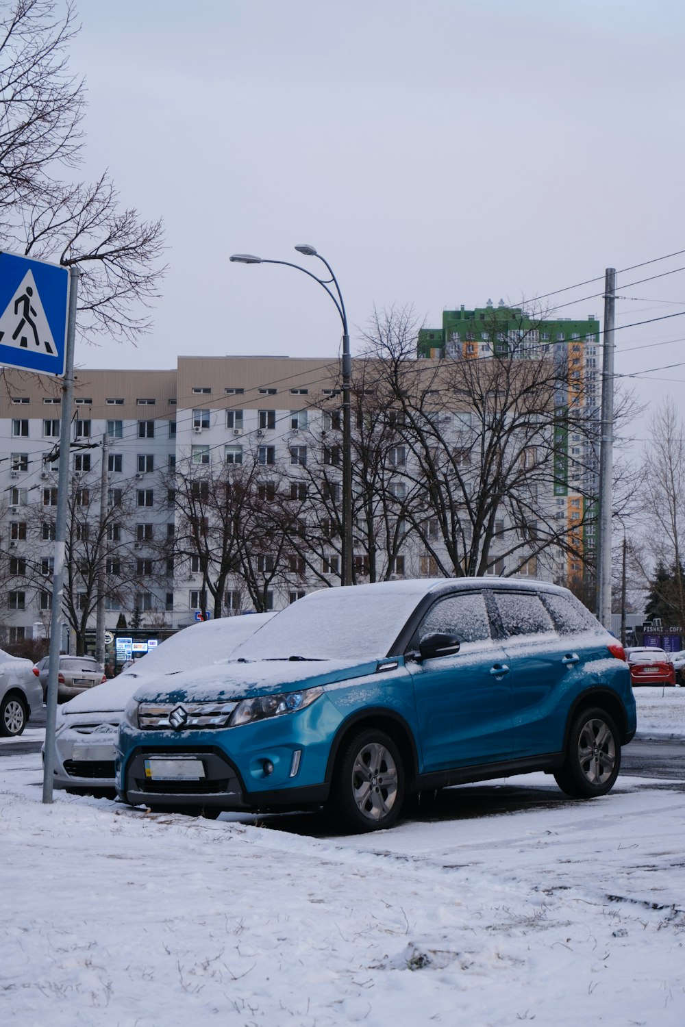 a blue car parked in the snow