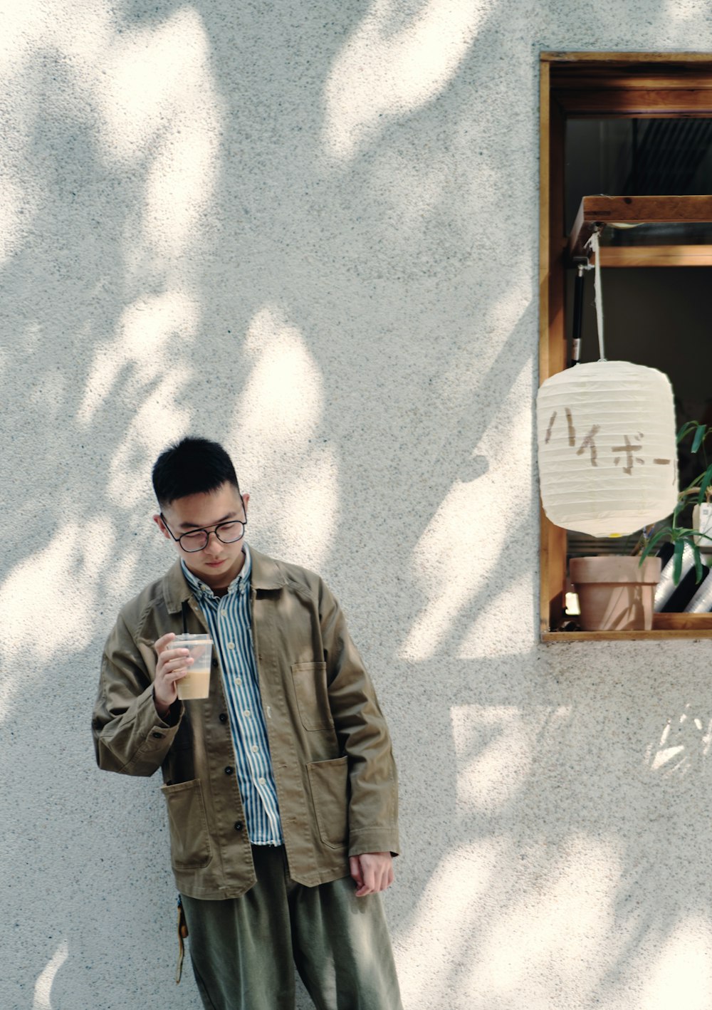 a man standing in front of a white wall