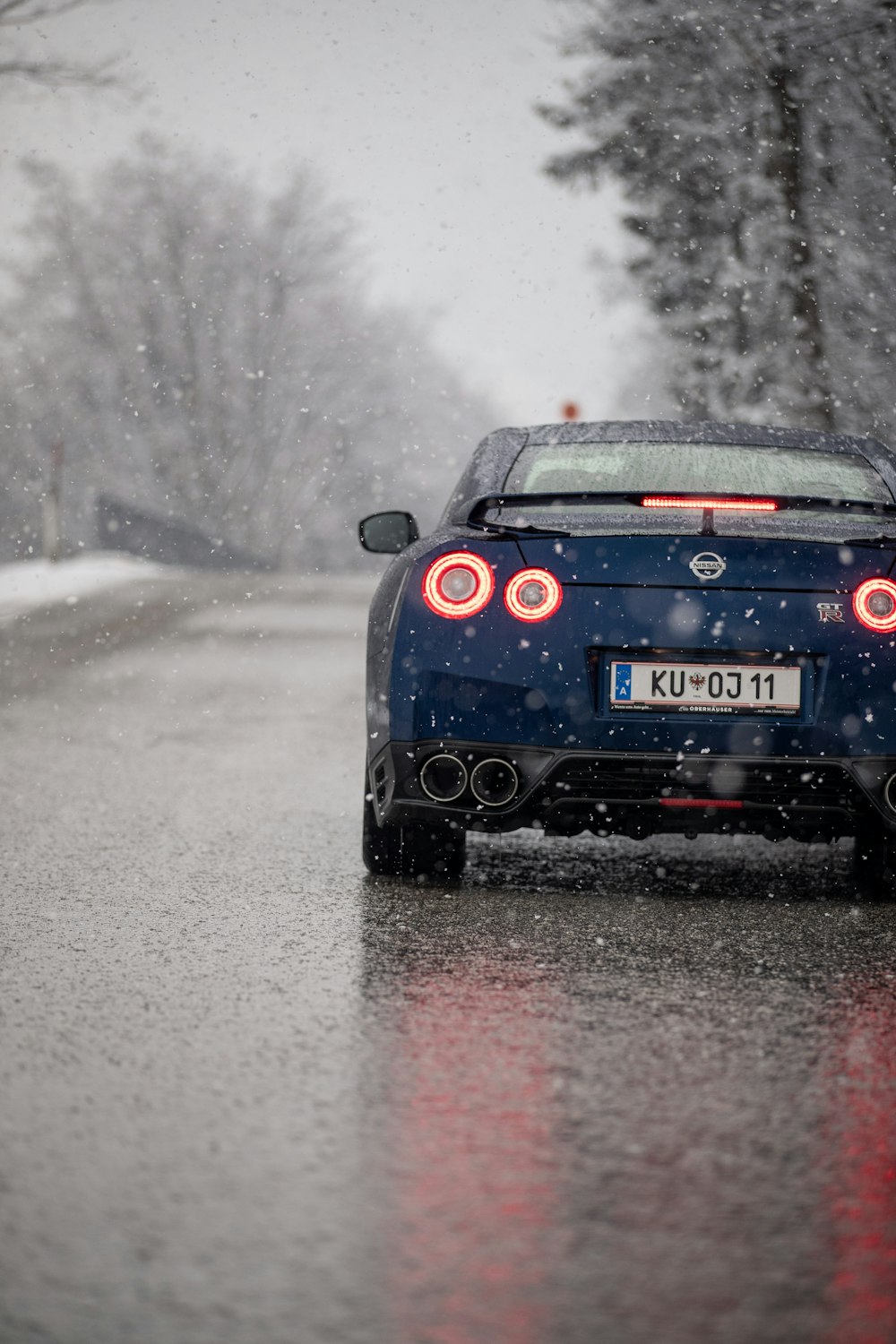 a car driving on a road with snow on the ground