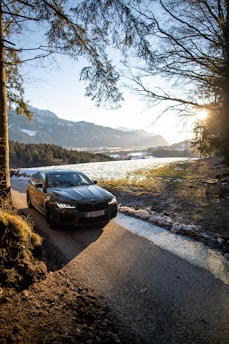 a car parked on a road by a river
