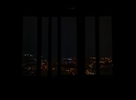 Evening cityscape viewed from Corpex Global’s office window, lights glowing warmly.