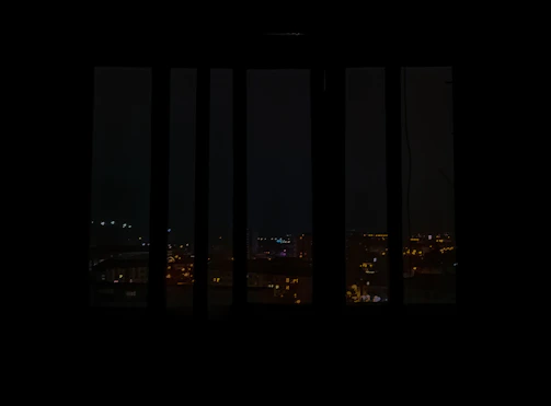 A panoramic view of a luxury apartment skyline at night, illuminated with warm golden lights.
