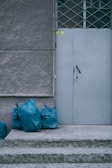 a white door with blue bags next to it