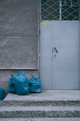 a white door with blue bags next to it